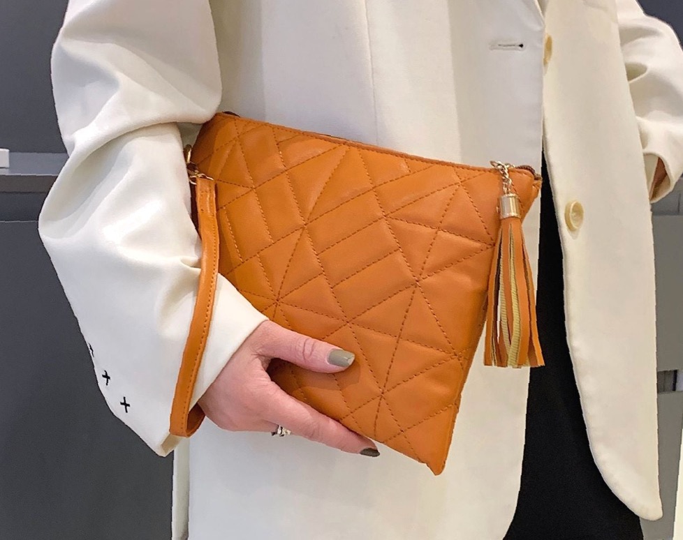 Mustard quilted clutch styled with a light jacket