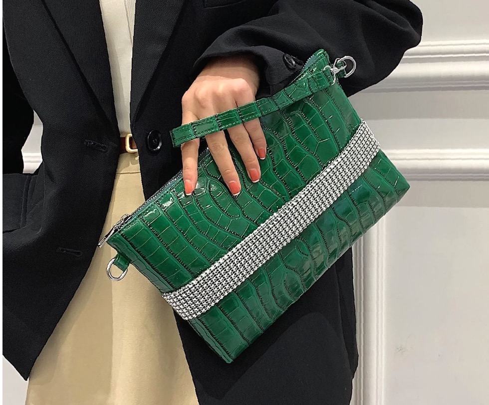 Green clutch styled with a black jacket in the Parisian edit