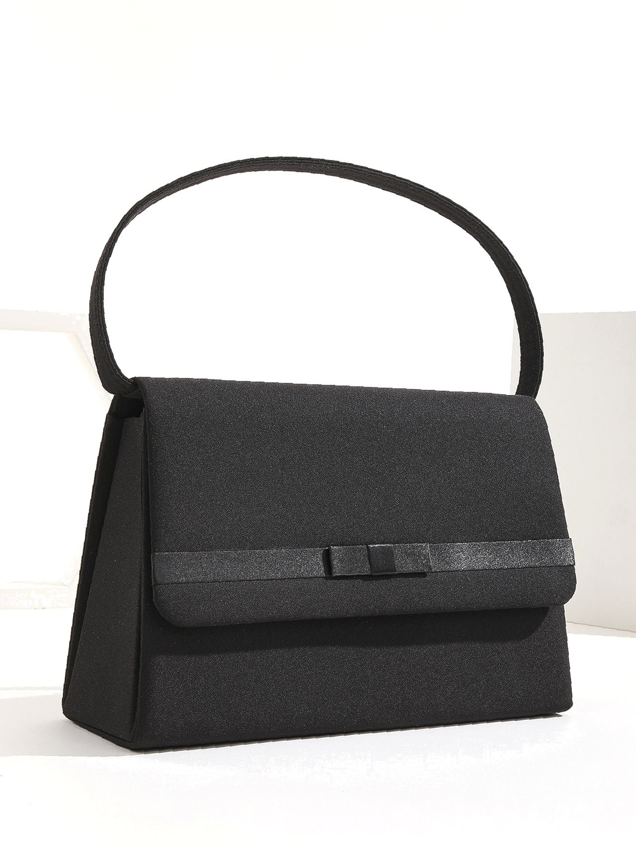 Black structured shoulder bag with a discreet bow detail